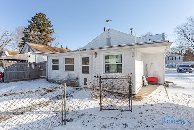 view of snow covered back of property