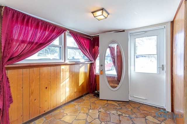 washroom with a healthy amount of sunlight and wooden walls