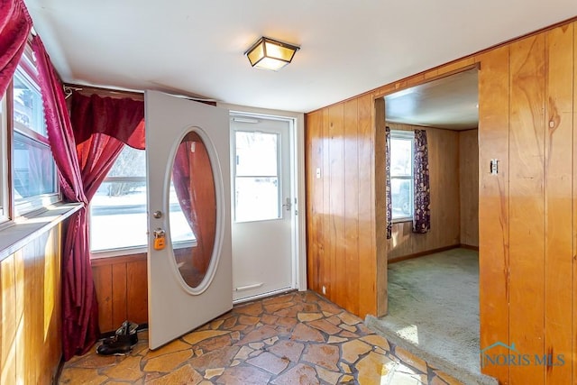 entryway featuring a healthy amount of sunlight and wood walls