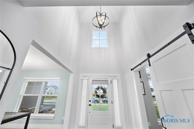 foyer entrance featuring a barn door and a notable chandelier