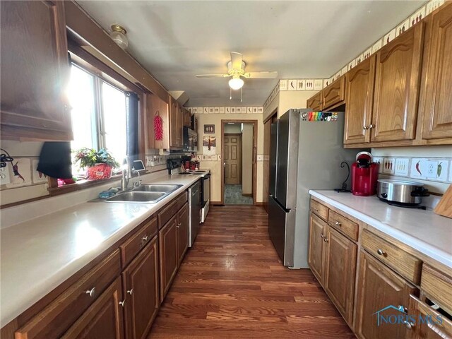 kitchen with dark wood-type flooring, ceiling fan, stainless steel appliances, and sink