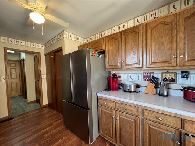 kitchen featuring dark hardwood / wood-style floors, stainless steel refrigerator, and ceiling fan