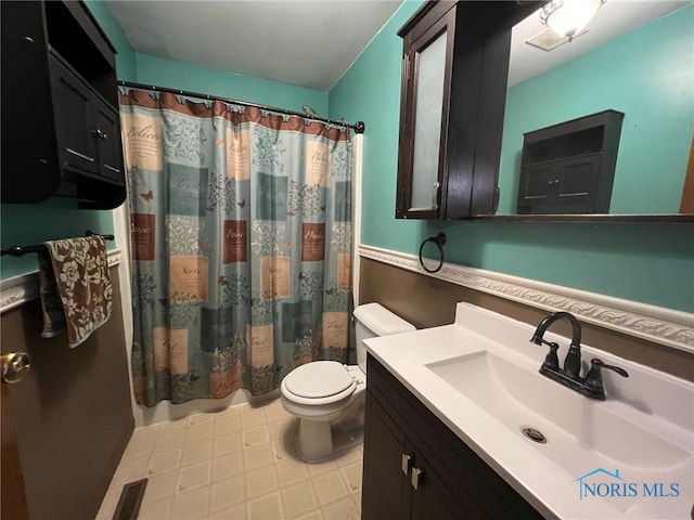 bathroom featuring vanity, walk in shower, and toilet