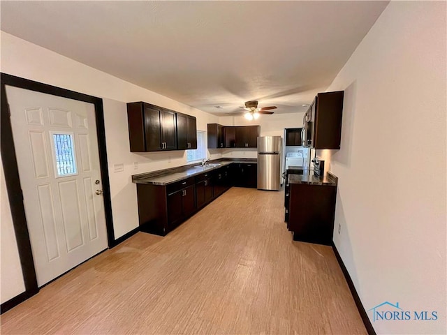 kitchen featuring ceiling fan, sink, stainless steel fridge, light hardwood / wood-style floors, and dark brown cabinets