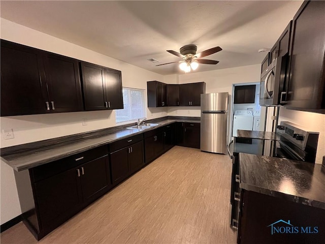 kitchen with appliances with stainless steel finishes, light wood-type flooring, dark brown cabinetry, ceiling fan, and sink