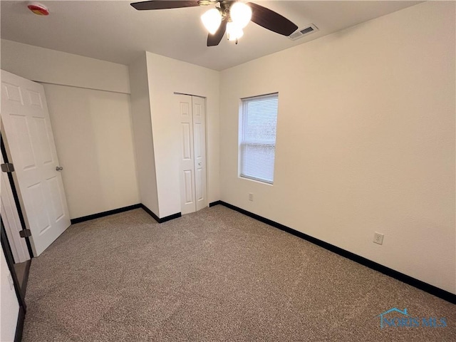 unfurnished bedroom featuring ceiling fan, a closet, and light carpet