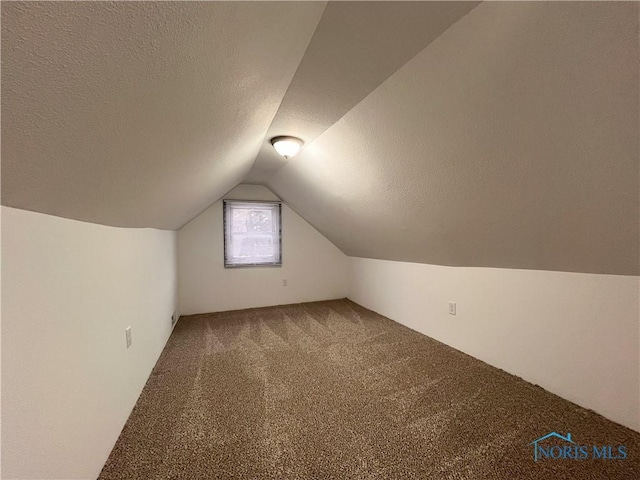 bonus room featuring carpet flooring, a textured ceiling, and vaulted ceiling