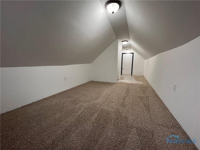 bonus room with a textured ceiling, carpet floors, and vaulted ceiling