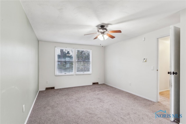 carpeted spare room with ceiling fan