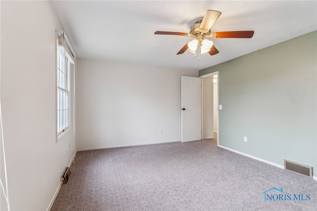 carpeted spare room with ceiling fan