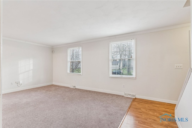 empty room featuring hardwood / wood-style flooring and ornamental molding