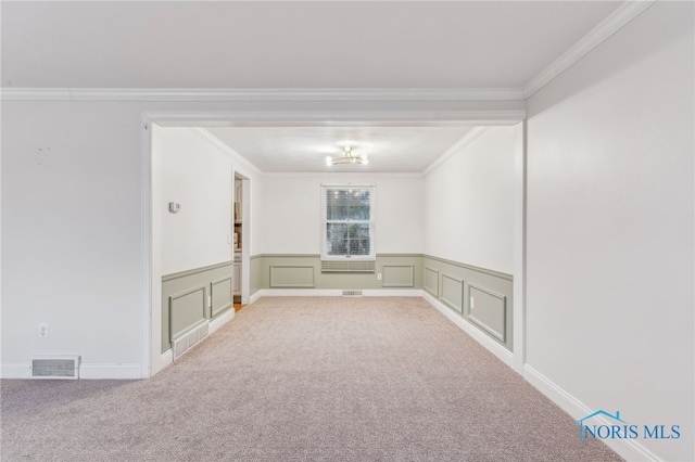 spare room featuring a notable chandelier, light colored carpet, and ornamental molding