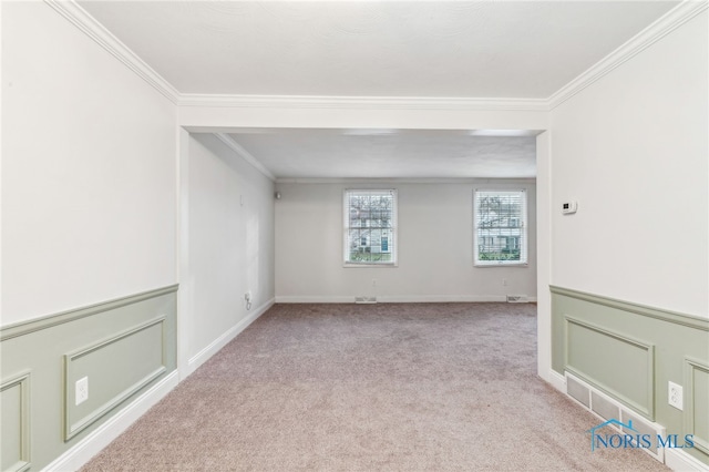 carpeted spare room featuring crown molding