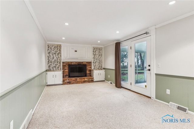 unfurnished living room with crown molding, light carpet, and a brick fireplace