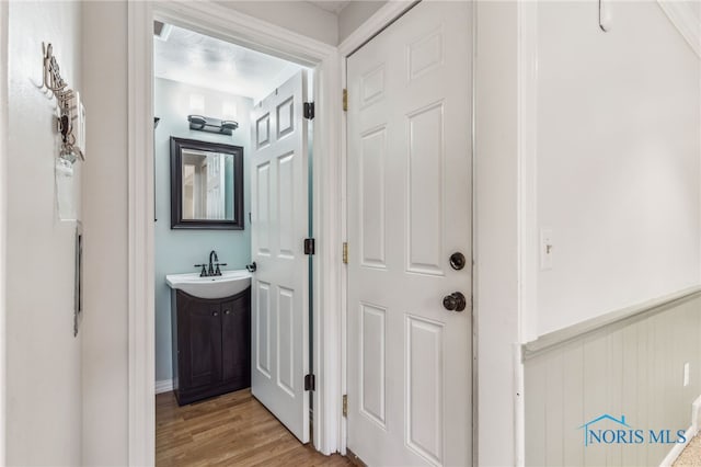 hallway featuring sink and light hardwood / wood-style floors