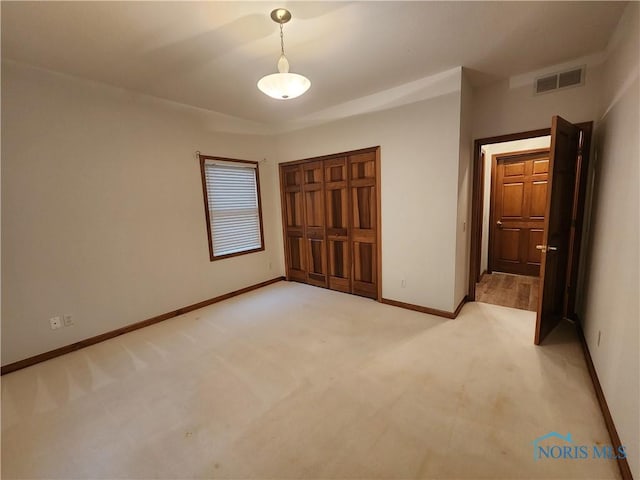 unfurnished bedroom featuring a closet and light colored carpet