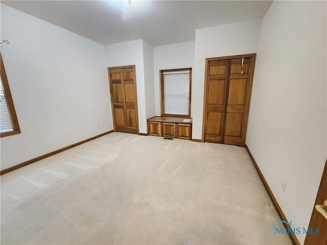 unfurnished bedroom with light colored carpet