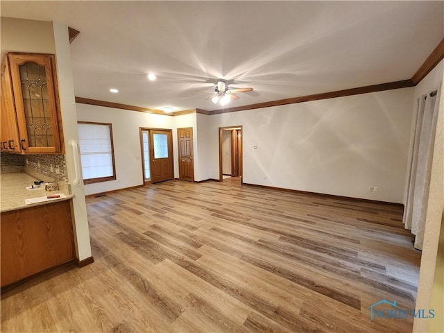 unfurnished living room featuring ceiling fan, light hardwood / wood-style flooring, and ornamental molding