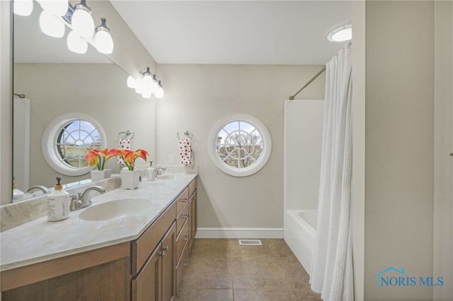 bathroom with tile patterned flooring, shower / tub combo, and vanity