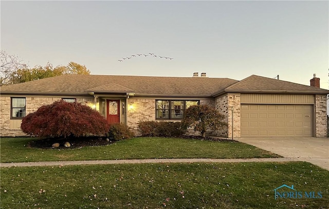 ranch-style house with a garage and a lawn