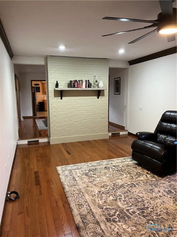 living room with crown molding and dark wood-type flooring