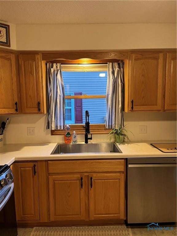 kitchen with a textured ceiling, dishwasher, black stove, and sink