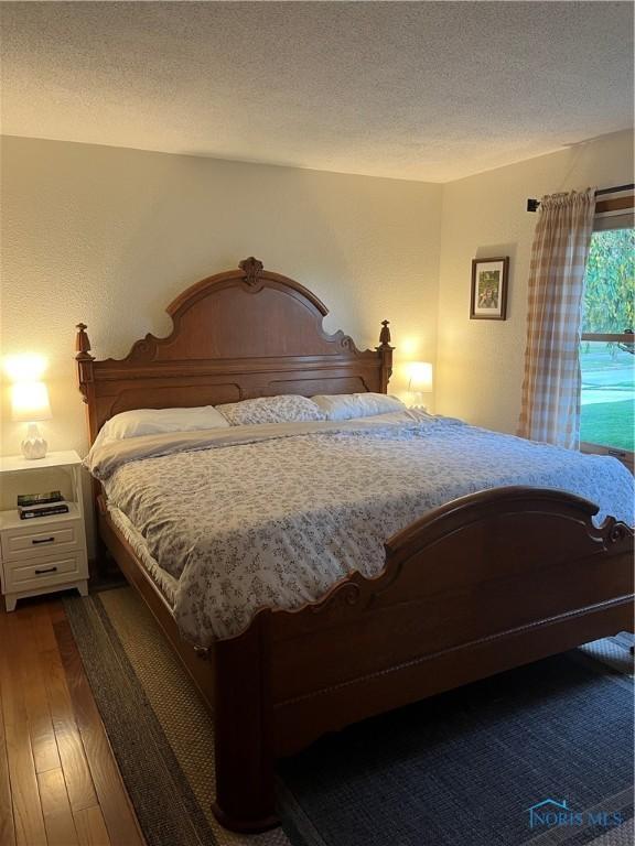 bedroom featuring dark hardwood / wood-style floors and a textured ceiling