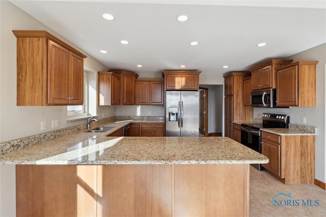 kitchen featuring light stone countertops, kitchen peninsula, stainless steel appliances, sink, and light tile patterned floors