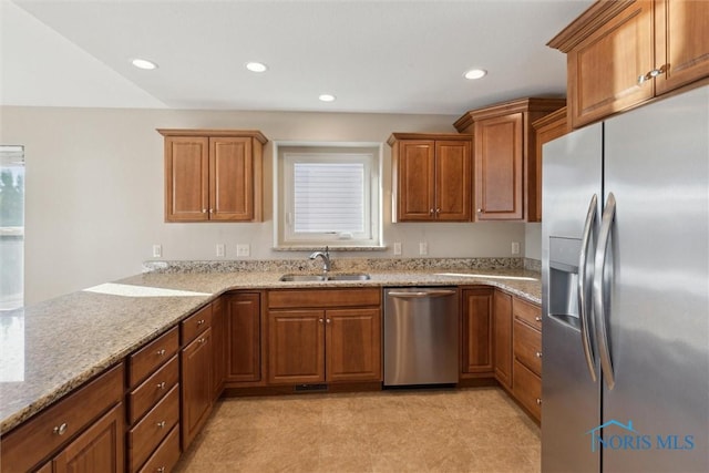 kitchen featuring sink, light stone countertops, and stainless steel appliances