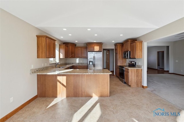 kitchen with sink, stainless steel appliances, light stone counters, kitchen peninsula, and light colored carpet