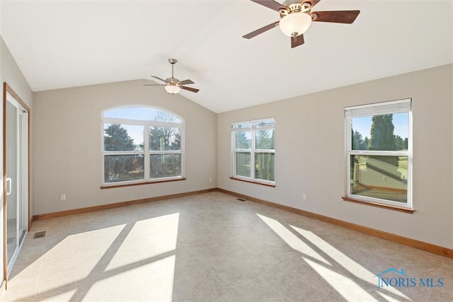 empty room featuring plenty of natural light and lofted ceiling