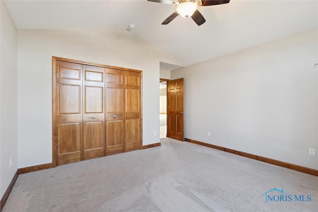 unfurnished bedroom with ceiling fan, light colored carpet, lofted ceiling, and a closet