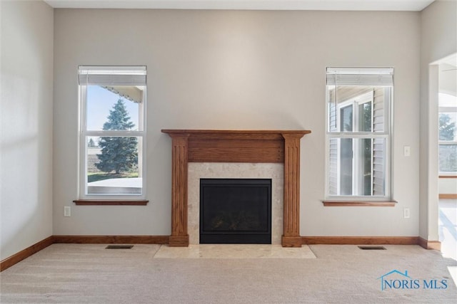 unfurnished living room with a fireplace, light carpet, and plenty of natural light