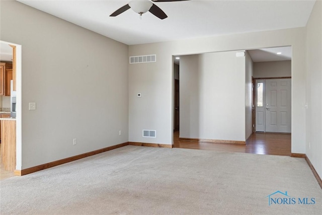 carpeted spare room featuring ceiling fan