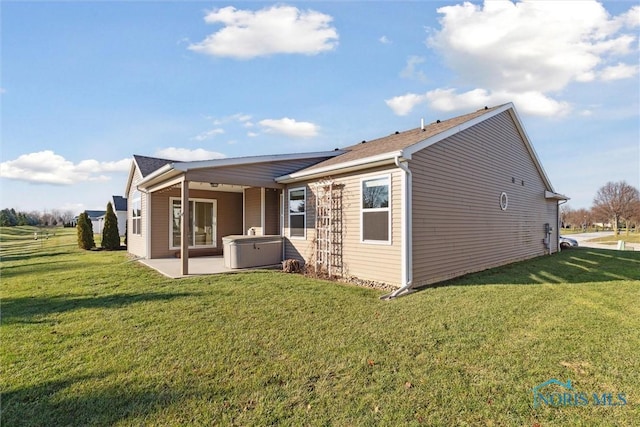 back of property featuring a lawn and a patio area