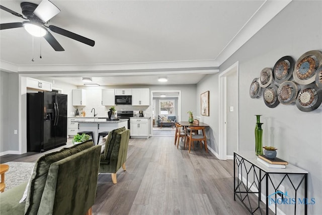 interior space featuring light hardwood / wood-style flooring, ceiling fan, and crown molding