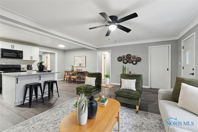 living room featuring ceiling fan, crown molding, and wood-type flooring