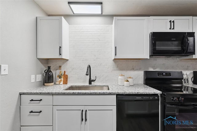 kitchen featuring light stone countertops, sink, backsplash, white cabinets, and black appliances