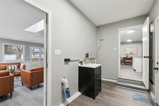 bathroom featuring vanity, wood-type flooring, and a skylight