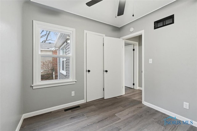 unfurnished bedroom with ceiling fan and wood-type flooring