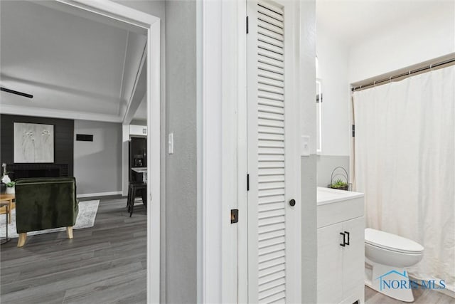 bathroom featuring hardwood / wood-style flooring, vanity, ceiling fan, and toilet