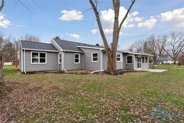 back of property with a lawn and a patio