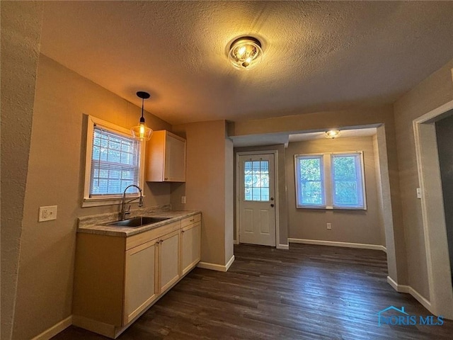 kitchen featuring a textured ceiling, hanging light fixtures, a healthy amount of sunlight, and sink