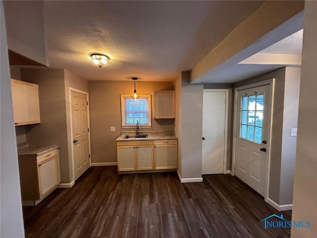 kitchen featuring pendant lighting, a textured ceiling, dark hardwood / wood-style floors, and sink