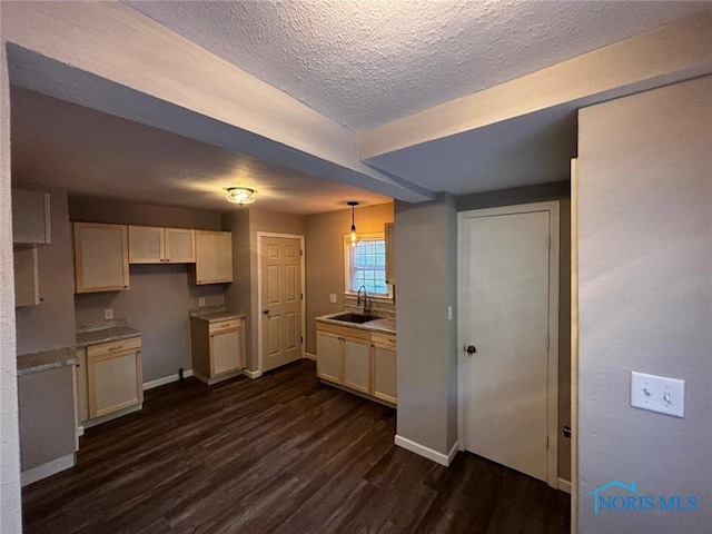 kitchen featuring pendant lighting, dark hardwood / wood-style flooring, a textured ceiling, and sink