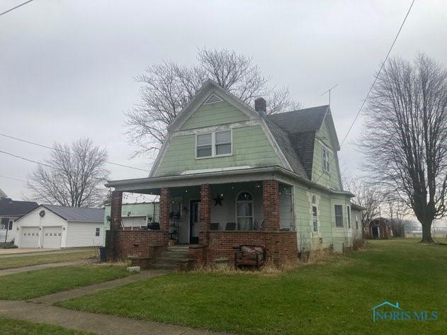 view of front of house featuring covered porch and a front lawn