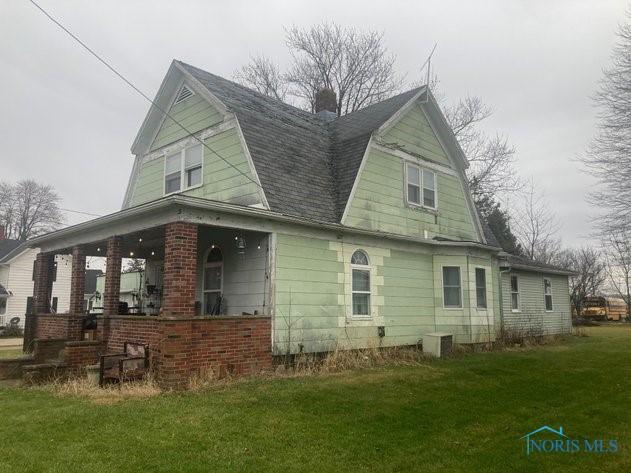 view of home's exterior with covered porch, central air condition unit, and a lawn