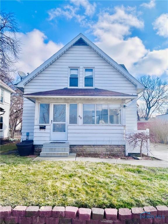 back of property with a sunroom and a yard