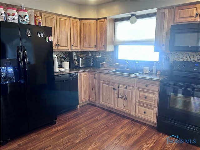 kitchen featuring dark hardwood / wood-style flooring, sink, stone countertops, and black appliances