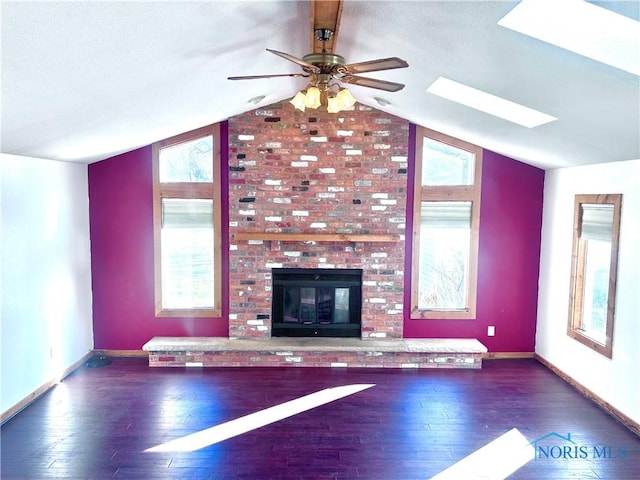 unfurnished living room with ceiling fan, a healthy amount of sunlight, and vaulted ceiling with skylight